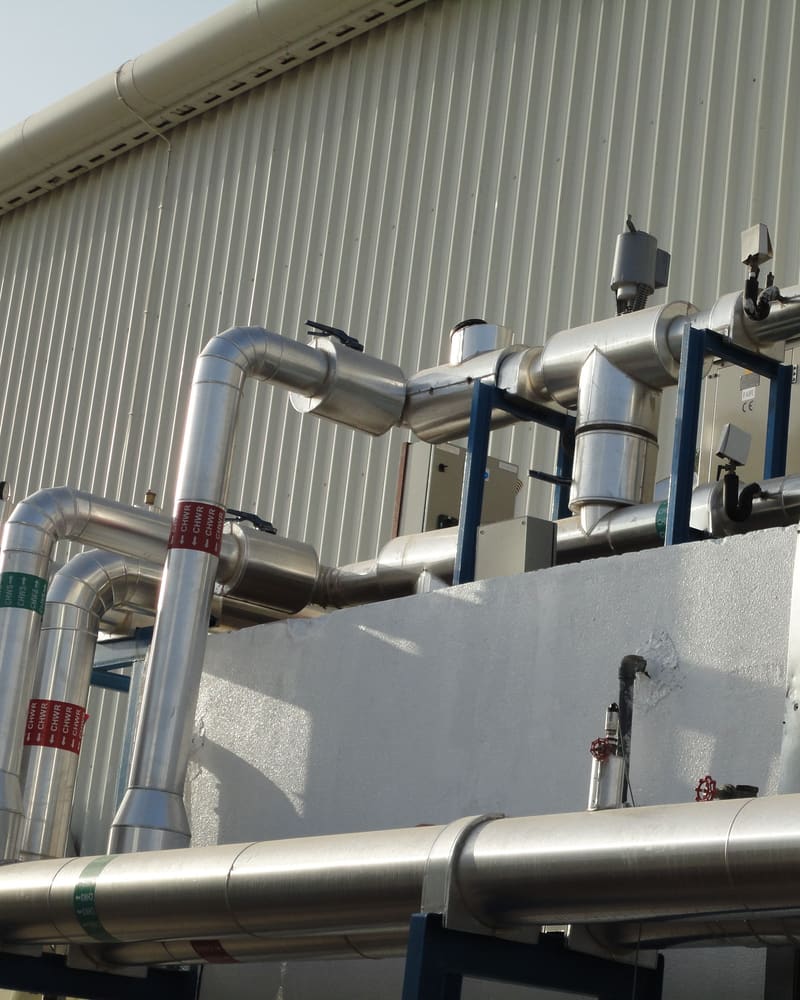 Insulated chilled-water pipework connecting to a rooftop air handling unit